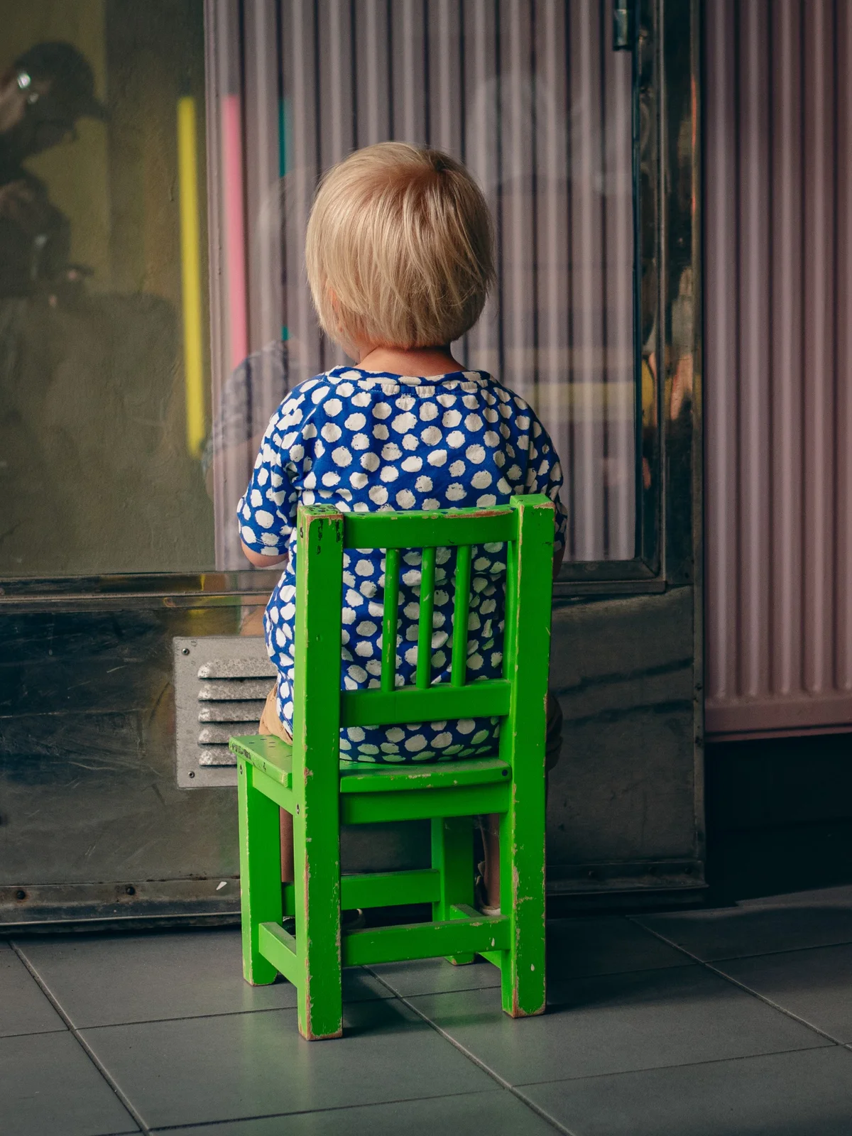 chid on chair stairing into a wall
